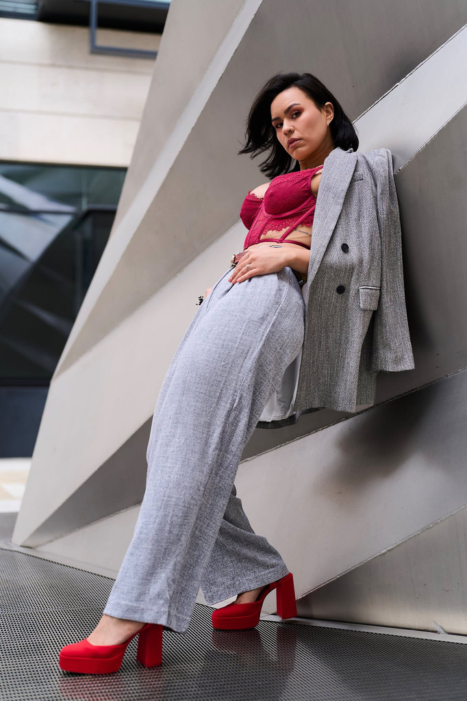 Hands hooked into the trouser loops, weight on one foot