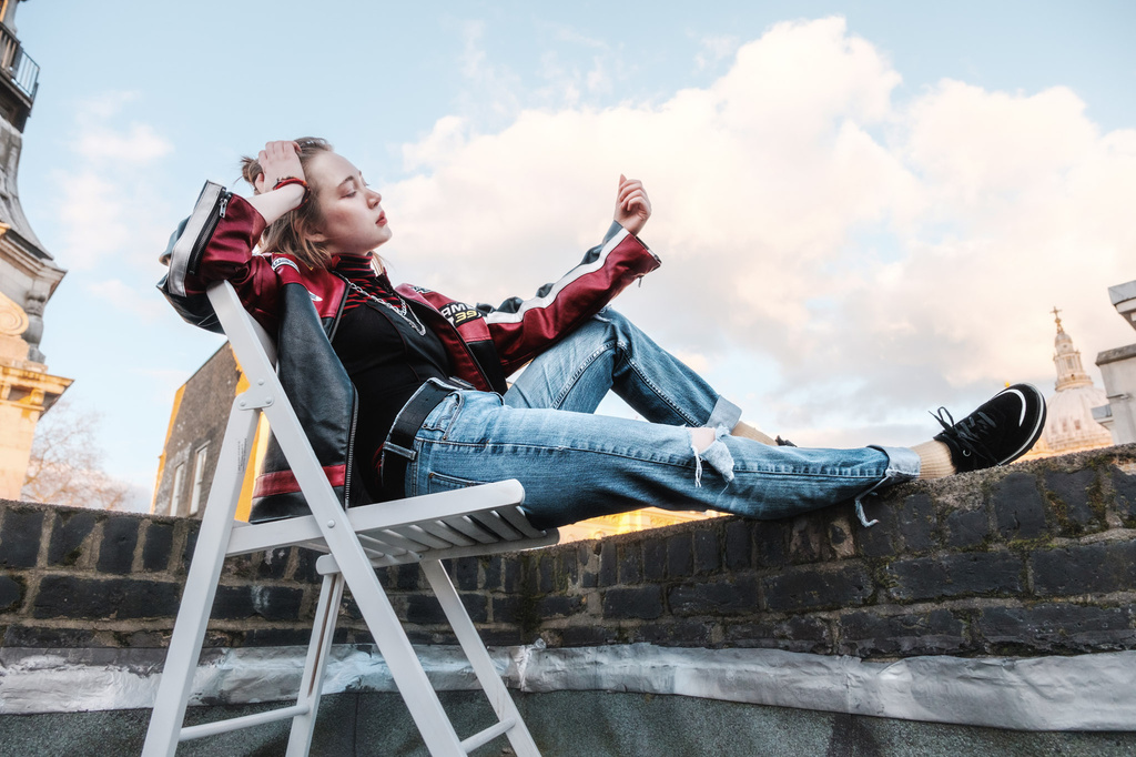 Leaning back in a chair, looking away from camera