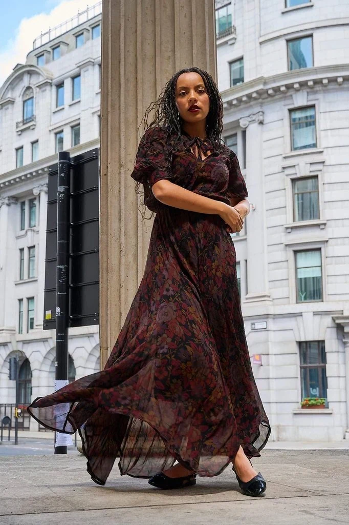 Slow, deliberate movement pose: Moving slowly and deliberately rather than holding completely still lets a flowing dress catch the motion and settle into soft, elegant shapes as you walk.