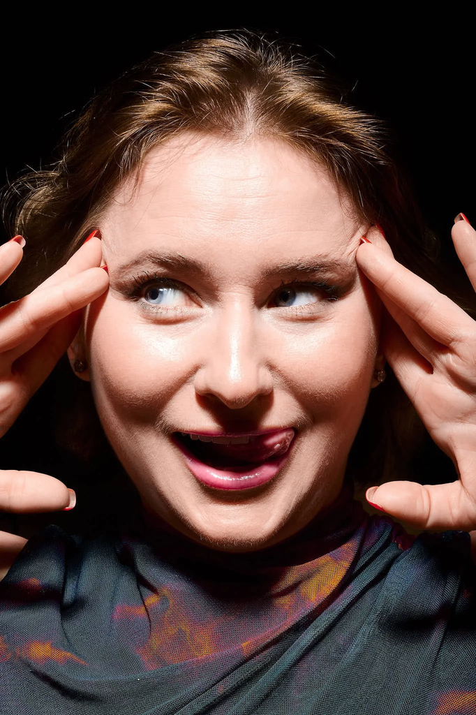 Tongue out, hands framing the temples
